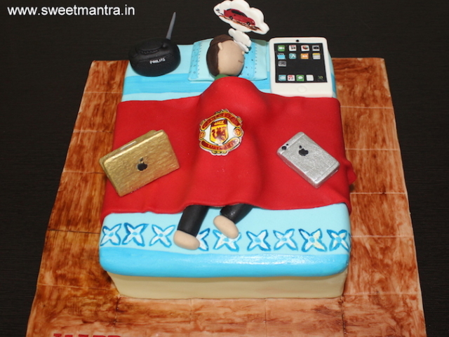 Husband dreaming on bed with gadgets cake in Pune