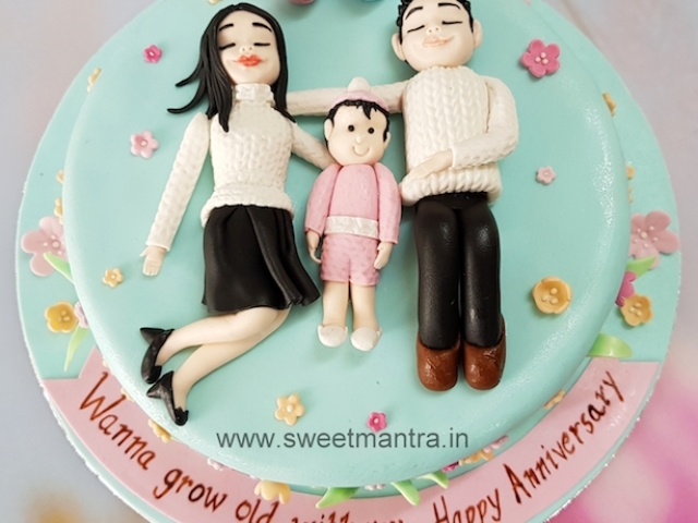 Anniversary theme designer cake with couple and newborn baby girl figurines in Pune