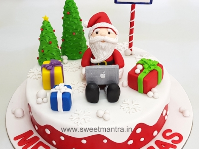 Christmas theme cake with Santa working on laptop for office celebrations at Pune